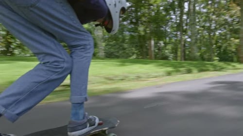 Skateboarder Rides Down Forest Path Safely Geared Up