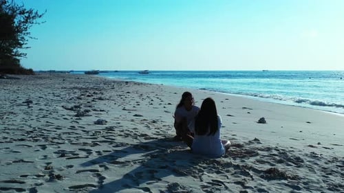 Sexy beauty models travelling spending quality time at the beach on clean white sand and blue backgr