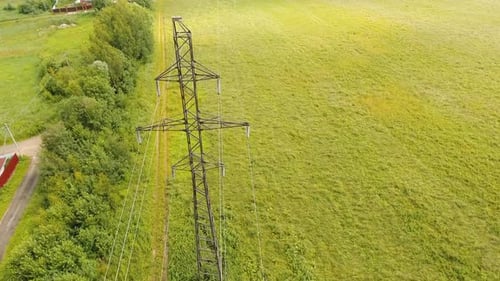 Aerial View of Power Lines Over Green Field