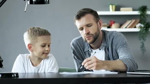 Father Helping Son With Homework at Home