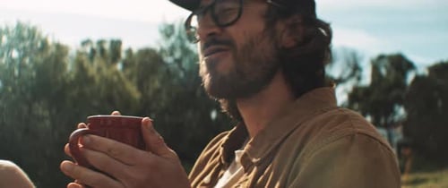 Man with Beard Drinks Coffee Outdoors