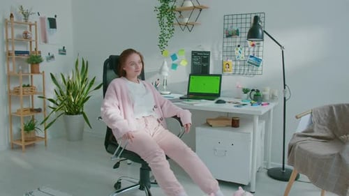 Woman in Slippers Relaxing at Desk with Laptop