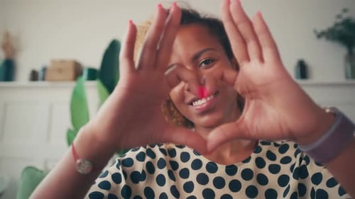 Young Woman Making Heart Shape with Hands