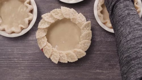 Preparing pie crusts for mini pumpkin pies.