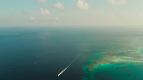 Seascape Coral Reef and Blue Sea with Motorboat