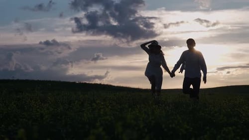 Countryside Cheerful Couple Rest in Nature Man and a Woman are Running Through a Rapeseed Field