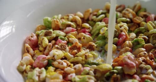 Milk Pouring Into Bowl of Colorful Cereal