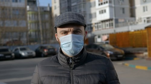 Man Wearing Surgical Mask in City Setting
