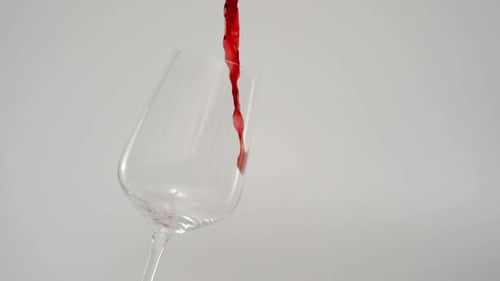 Derramando vinho tinto em vidro inclinado a 1000 Fps de fundo branco