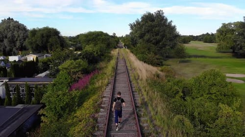 Man walking on railroad in Swedish summer