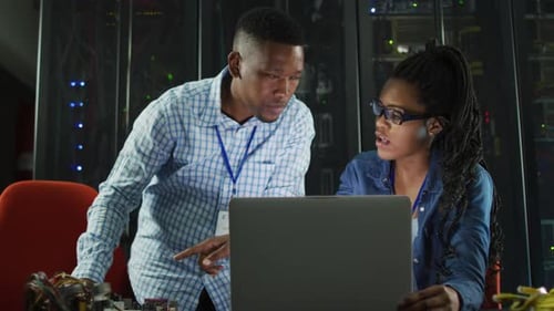 Afroamerikanische Computertechniker arbeiten mit Laptop im Business-Serverraum