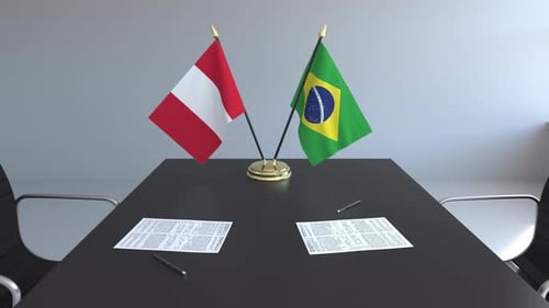 Peru and Brazil Flags Waving on Corporate Meeting Table