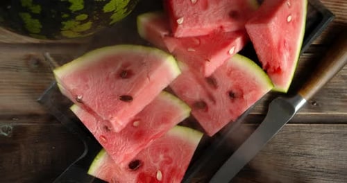 Pieces Ripe Watermelon on Cutting Board with Cool Steam.