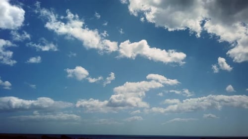 Clouds Rolling Across Blue Sky over Ocean Time Lapse