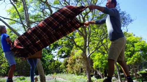 Family Preparing for Picnic in Summer Meadow