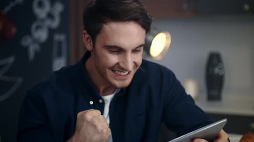 Portrait of Excited Man Getting Good News on Tablet Computer in Home Office.