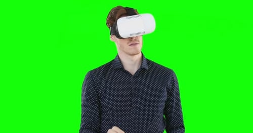 Caucasian man wearing a VR headset on green background
