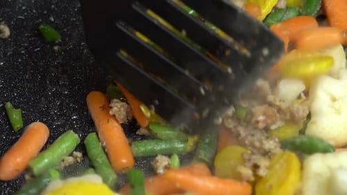 Nahaufnahme von dampfender Bratpfanne und gemischtem Gemüse mit Hackfleisch