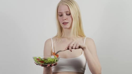 Woman Enjoys Healthy Salad in Studio Setting