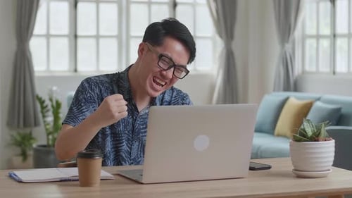 Man Working on Laptop Celebrates Success