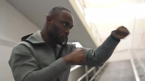 African man athlete do sport training boxing exercise in crossing street tunnel in the city at night