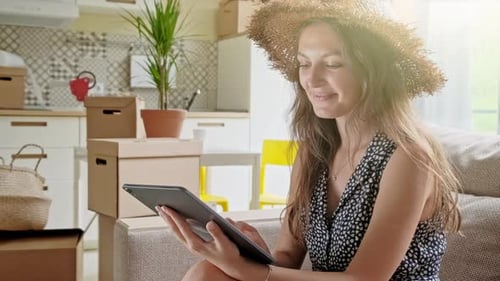 Woman Using Tablet Amid Moving Boxes at Home