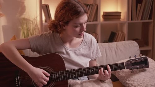 Woman Plays Guitar Relaxing at Home