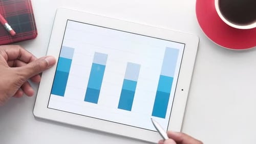 Man's Hand Working on Digital Tablet at Office Desk, Using Self Created Chart