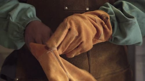 Worker Putting on Gloves in Workplace Close-up