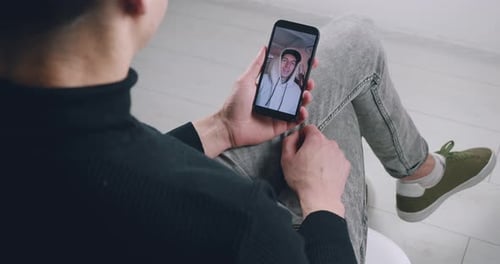 Nahaufnahme: Mann schaut Internet-Videoblog mit Smartphone an