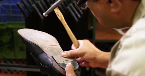 Craftsman Repairing Heel of Shoe with Hammer