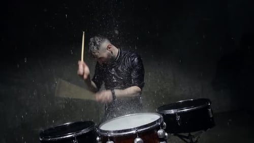 Male Drummer Plays Energetically in the Rain