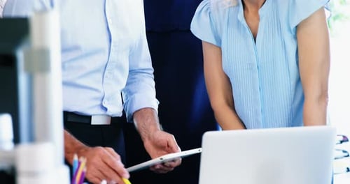 Professionals Collaborating on Tech Projects in Modern Office