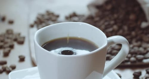 Cream Added to Coffee in White Cup
