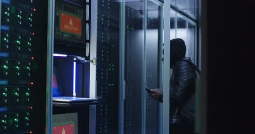 Black Man Hacking Computer System in Server Room