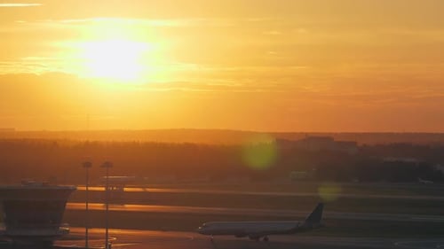 - Flughafenblick mit fahrendem Flugzeug bei goldenem Sonnenuntergang