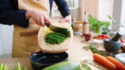 Chopped Greens Being Added to Bowl on Table