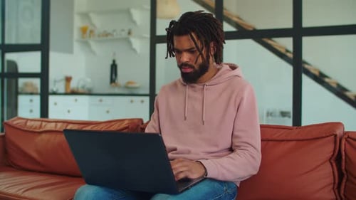 Freelancer noir créatif avec ordinateur portable travaillant sur un projet