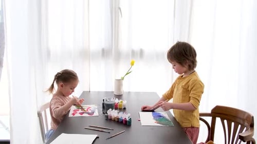 Two Children Painting Together at a Table