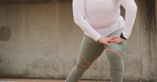 Woman Stretching Leg in Urban Environment