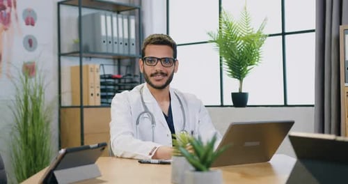 Doctor Working on Laptop in Bright Office
