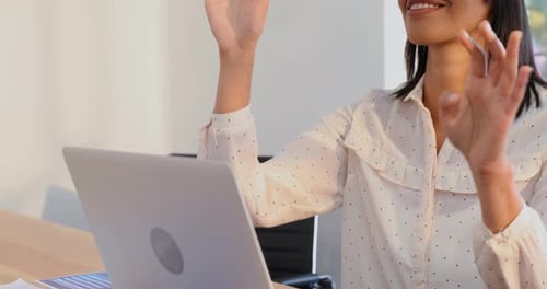 Woman Using VR Headset at Work on Laptop