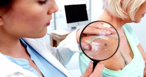Doctor Examines Patient with Magnifying Glass in Office