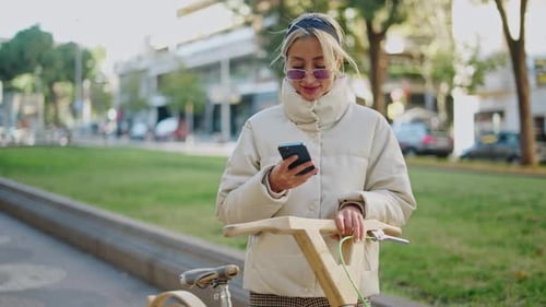 Female Cyclist Using Smartphone in Park