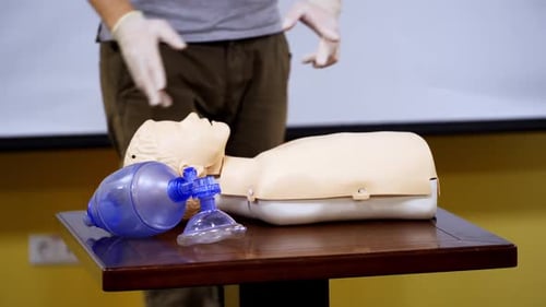 Medical male dummy lays on training table in hall.