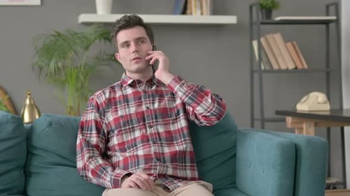 Man Talking on Smartphone While Sitting on Couch