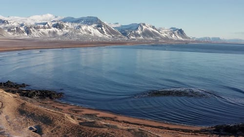 Drone Flight Over Icy Coastline And Sea Towards Mountains
