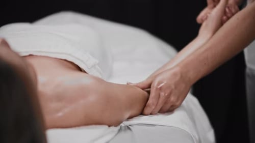 Young Woman Receiving a Massage in the Studio Soft Massaging Her Hand with an Oil