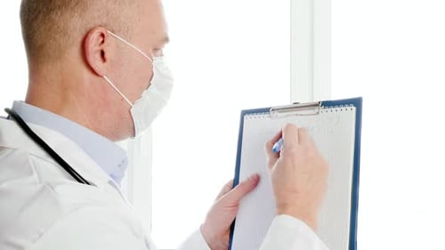 Concerned Doctor Writes Coronavirus on Notepad