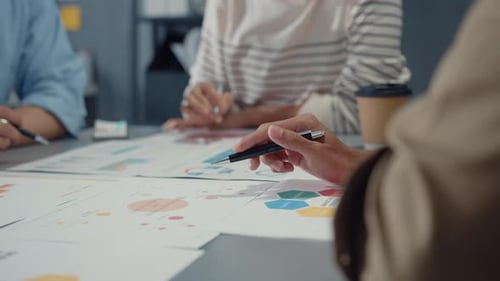 People Discussing Charts in Modern Workplace